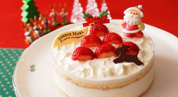 Fundo vermelho e verde, com detalhes amarelos na parte verde.  Ao centro vemos um prato branco, de porcelana. Dentro dele, uma torta branca, cremosa, com morangos dispostos tal como uma árvore de Natal, com um Papai Noel do lado direito, decorando o bolo (na ponta superior), e uma rena encostada em um morango, na parte inferior direita. 
Do lado esquerdo uma plaquinha escrita "Joyeux Noël, I wish for your happiness".